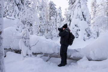 Phographer in snowy forest
