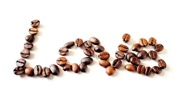 Love sign with coffee beans arranged over white background