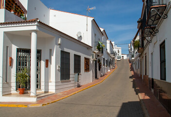 Casas blancas en las calles encaladas de un pequeño pueblo andaluz. La empinada calle Juan Ramón...