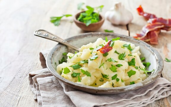 Mashed potatoes in old panl decorated parsley herbs and roasted bacon pieces