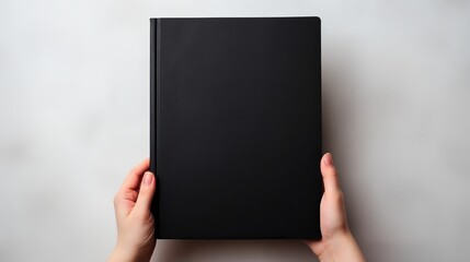 Vertical orientation captures female hands holding a large black book