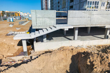 A concrete bench placed in the midst of a bustling construction site with workers and machinery...