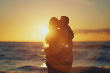 Couple hugging on the beach at sunset. Silhouettes of two lovers in the rays of the setting sun on the sea. The scene is romantic and calm