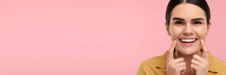Woman with clean teeth smiling on pink background, space for text. Banner design