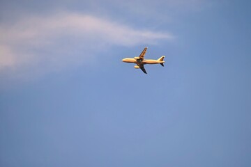Commercial plane in the blue sky at sunset.