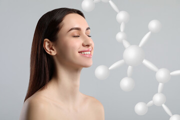 Beautiful woman with perfect healthy skin and molecular model on grey background. Innovative...