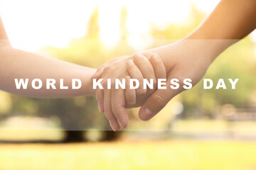 World Kindness Day concept. Woman and child holding hands outdoors, closeup