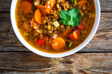 Fresh vegetable soup with lentil on wooden table
