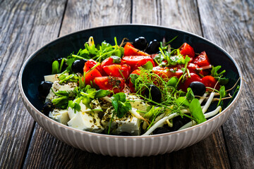 Greek style salad - fresh vegetables with feta cheese on wooden table

