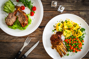 Lamb chops with bone and fresh vegetables on wooden table