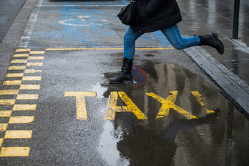 closeup of legs of woman jumping on the water puddle at the taxi station in the street of brussels - Belgium  - 749884487