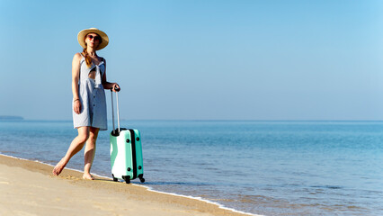 a girl by the sea with a travel suitcase