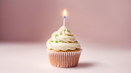 Lit candle decorating a cupcake amidst soft pink setting 
