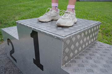 Winner of competition. Leadership and strategie. unrecognizable person in sports shoes on podium