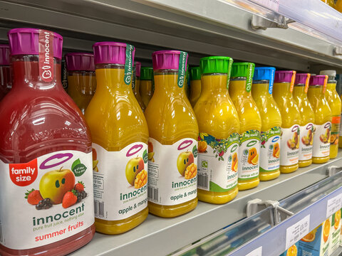 Kinds of innocent fruit juice displayed on the shelves of a supermarket. Innocent Drinks is a company that produces smoothies and juice owned by Coca-Cola Company.