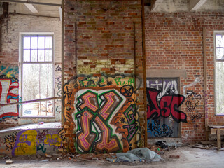 Brick wall with graffiti in an abandoned factory
