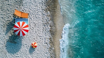 Top view of Beach scene with a parasol, beach chair, and beach ball on a sandy shore with copy space on left side