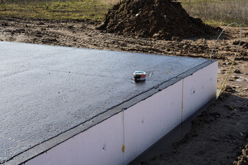 A piece of the base plate of a house. It is coated with a black insulating layer.