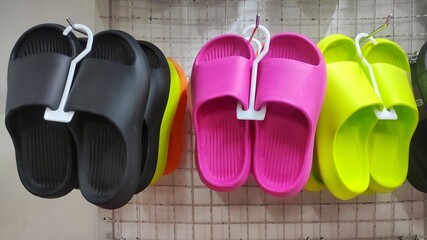Colourful slippers displayed on display rack in the inventory store to attract customer to buy
