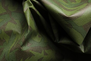 Texture of crumpled camouflage fabric as background, top view
