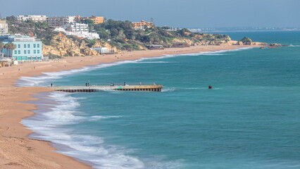 Wide sandy beach and Atlantic ocean in city of Albufeira timelapse. Algarve, Portugal
