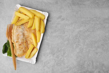 Delicious fish and chips served on gray table, top view. Space for text