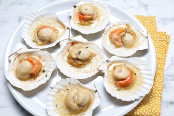 Fried scallops in shells on white marble table, above view