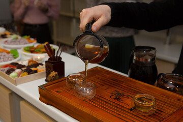 tea ceremony. a man pours tea from a glass teapot. Chinese traditions. green tea.