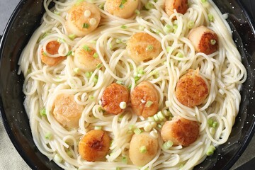 Delicious scallop pasta with green onion in pan, top view