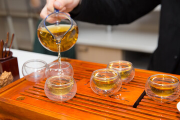 tea ceremony. a man pours tea from a glass teapot. Chinese traditions. green tea.