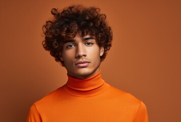 Fototapeta na wymiar young man with curly hair in a turtle neck orange shirt isolated winter times