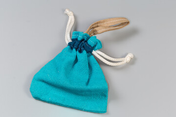 Empty blue fabric pouch with rope closure on gray background