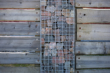 
Fence with stone post and wooden board wall