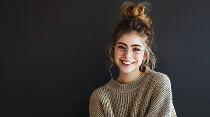 Foto op Canvas A fashionable young lady with a disheveled hairstyle, donning a warm, oversized sweater and stylish glasses, chuckles merrily against a warm, dark backdrop © Stone Shoaib