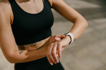Close up of woman looking at smartwatch and counting calories burned. Healthy life concept 