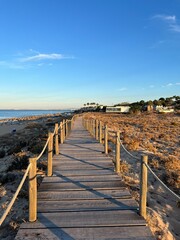 Fototapeta premium Wooden promenade at the ocean coast, ocean coastline, early morning sky, no people
