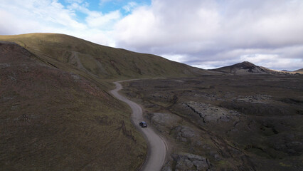 Car driving off-road terrain exploring the Fjallabak Natural Reserve. A 4x4 car driving dirt road traveling in Iceland sightseeing wilderness.