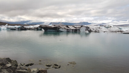 Floating icebergs in the Jökulsárlón Glacier Lagoon against cloudy sky, in southeast Iceland, on...
