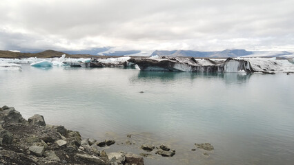 Floating icebergs in the Jökulsárlón Glacier Lagoon against cloudy sky, in southeast Iceland, on...