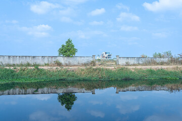 Serene River and Lakeside Landscape, Embracing Nature's Beauty in Spring, with Sky, Trees, and Architecture in the Background