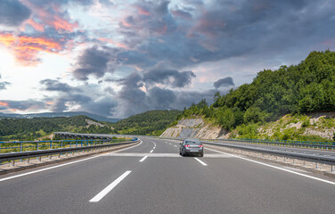 Country road with rocky mountains in the background.