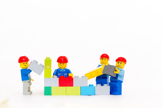 Orvieto, Italy - January 16th 2015: team of workman Lego mini figure build a wall. Lego is a popular line of construction toys manufactured by the Lego Group