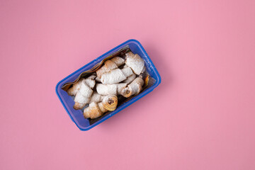 Homemade vitushki cookies in a blue mold on a pink background.