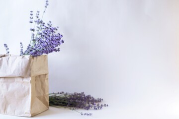 Lavender flowers in a craft paper bag on a white background.