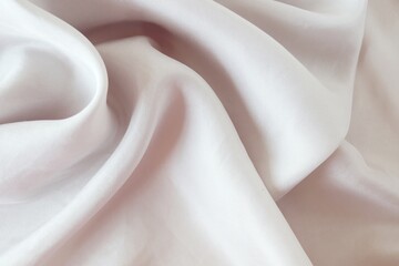 Beige color natural silk draped with folds, top view, fabric texture, pastel shades background