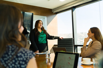 Plus size Latin businesswoman sharing her ideas during a business presentation with her boss