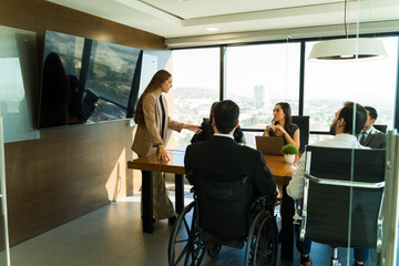 Obraz premium Businesswoman giving a sales pitch in a meeting room with diverse people and clients