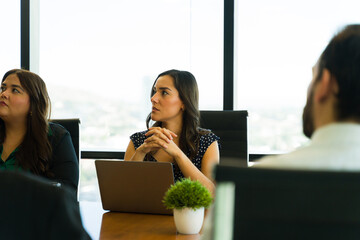 Hispanic businesswoman paying attention to a business presentation