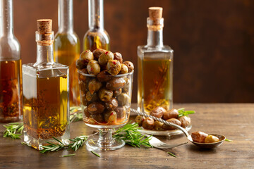 Spicy olives and bottles of olive oil on a wooden table.