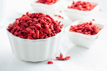 Dried goji berries on a white table.